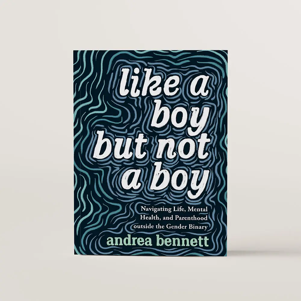 Book cover of Like a Boy but Not a Boy by andrea bennett. The text is handwritten with wavy blue lines like ripples spreading outward from the text in various shades of blue. 
