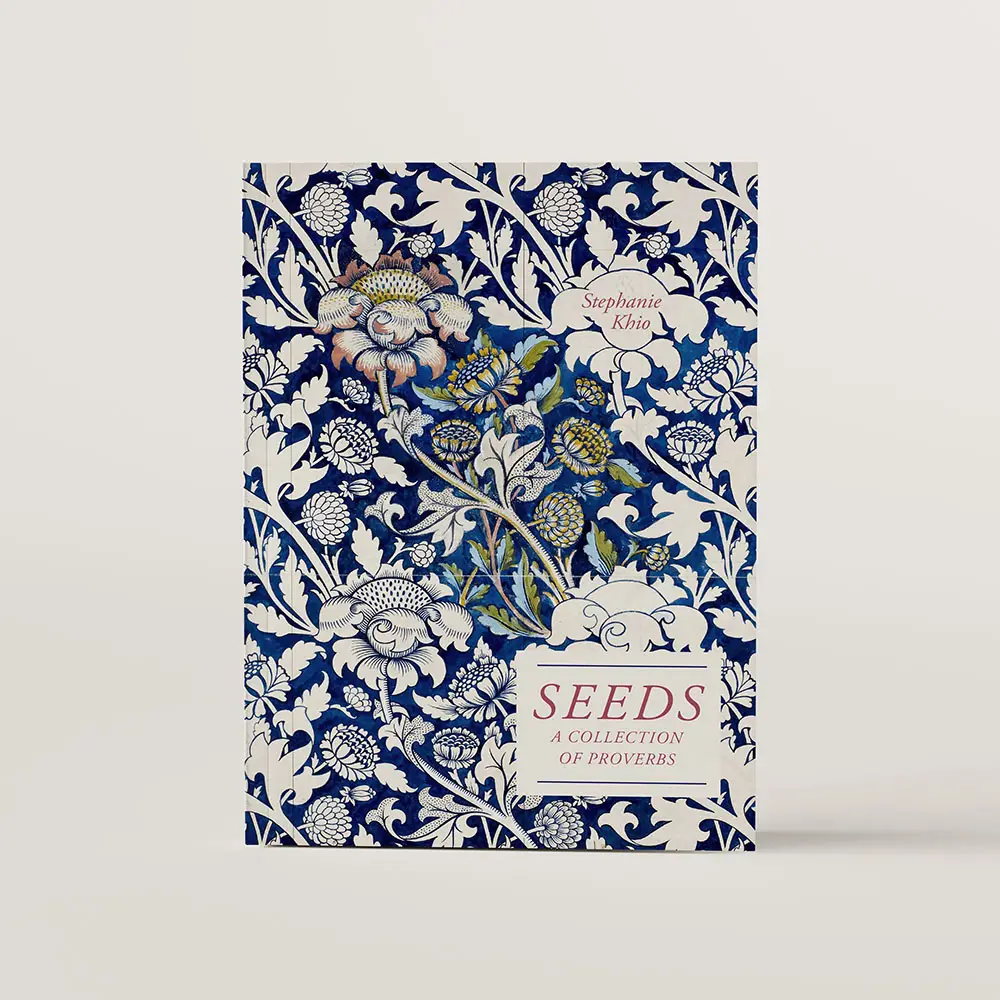 The book cover of Seeds by Stephanie Khio. The cover features an intricate blue and cream wallpaper design by William Morris. 