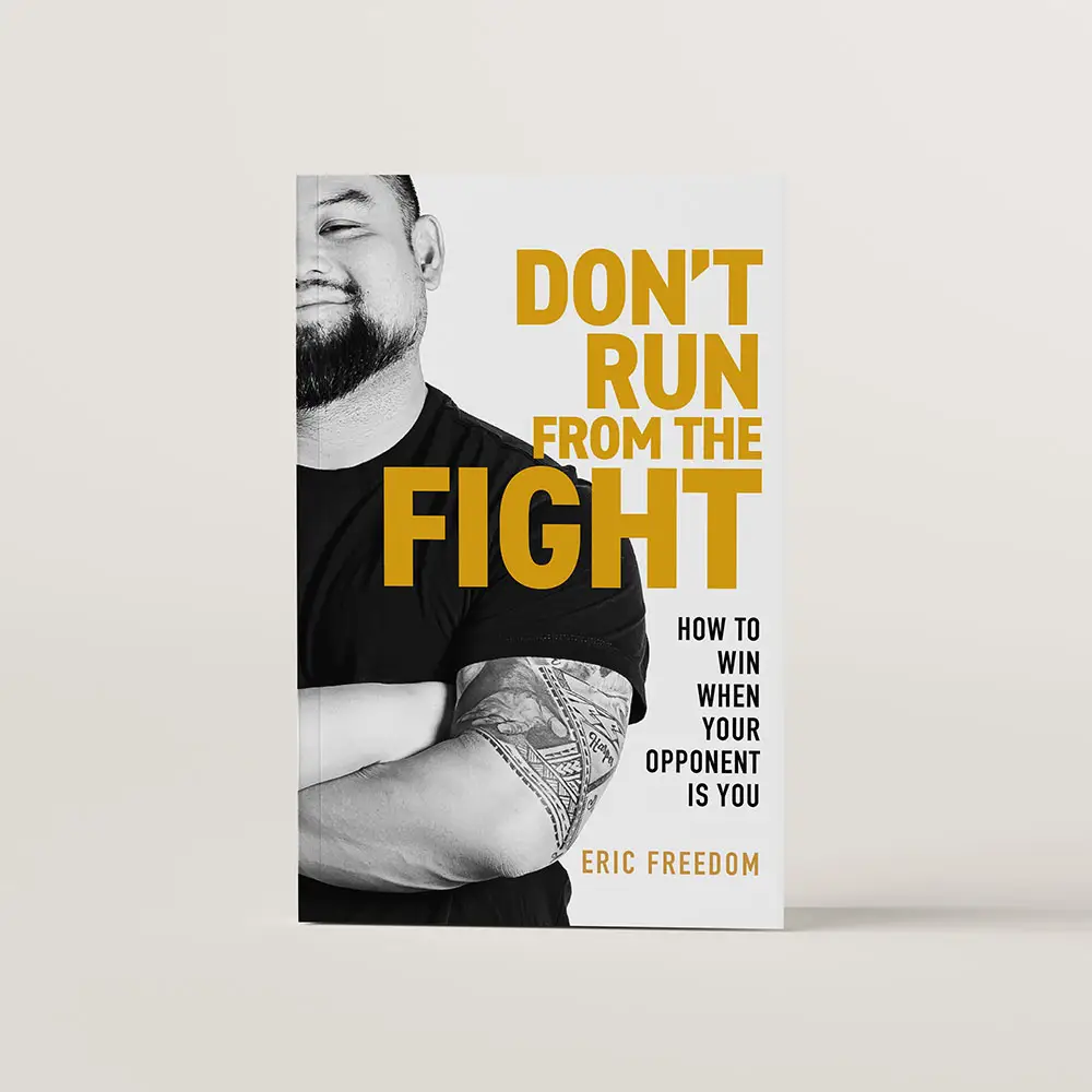 Don't Run From the Fight book cover featuring a black and white photo of the author Eric Freedom with his arms crossed and a smile on his face.